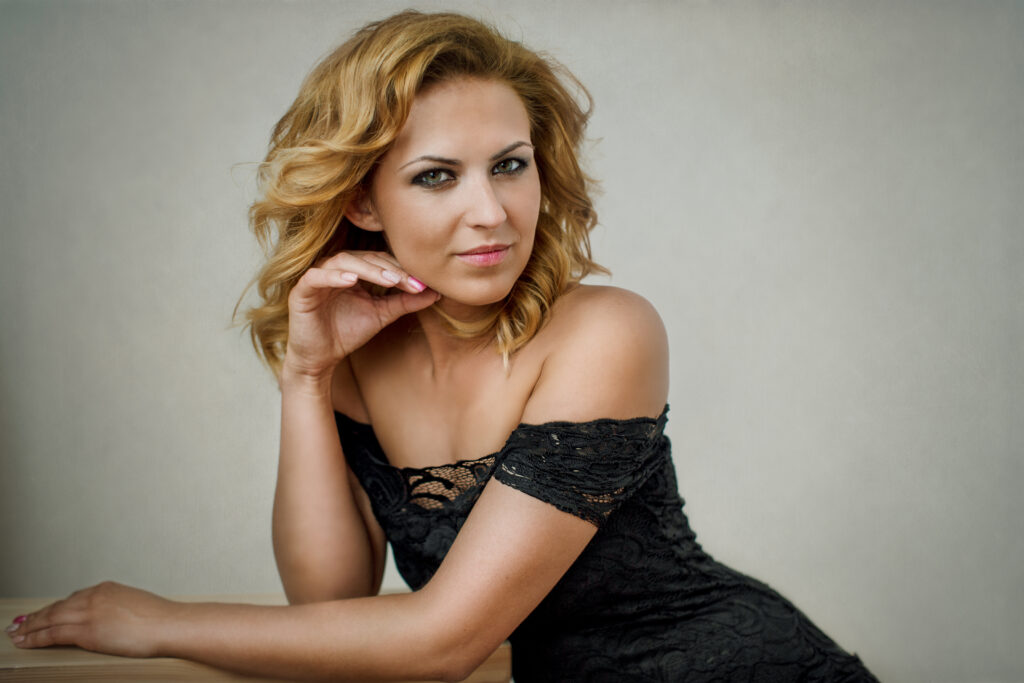 Blonde woman in a black dress, reclining – glamour photography by Takács Bori, Budapest