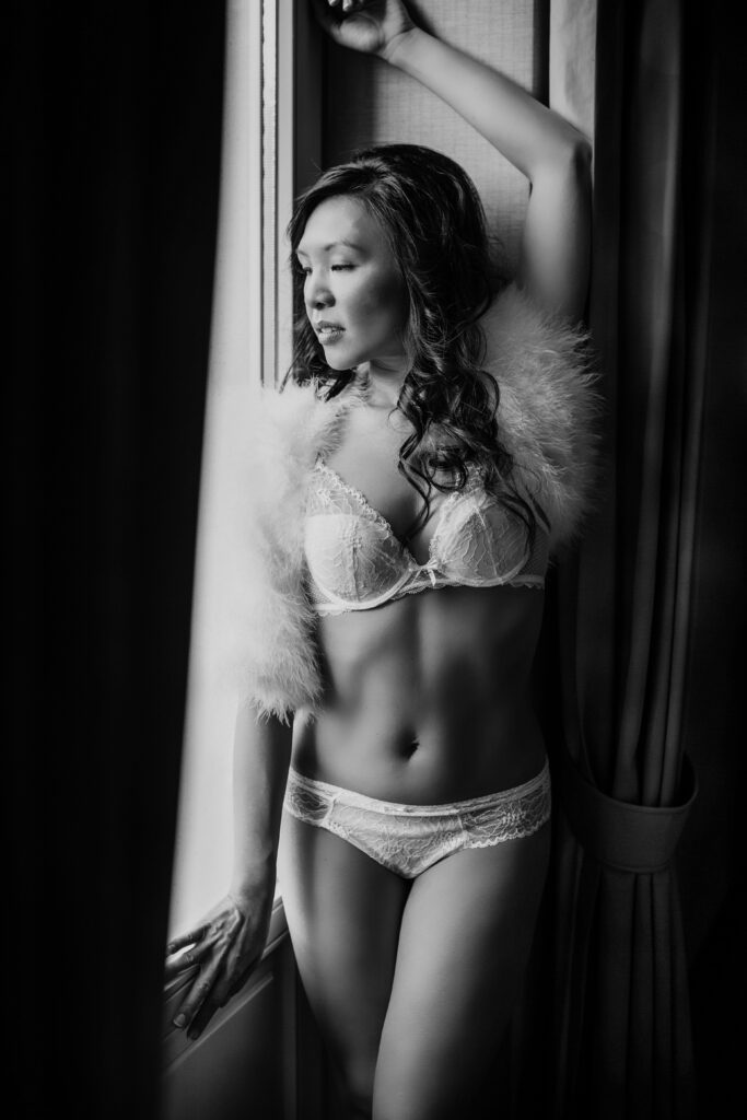 Black-and-white image of a woman by the window – boudoir photography by Takács Bori, Budapest