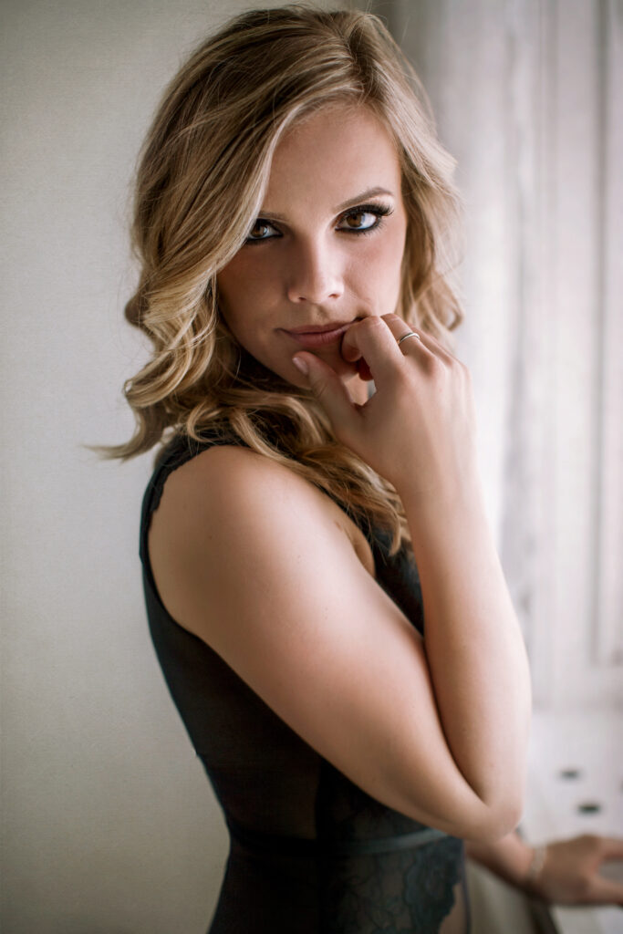 Blonde woman in black lingerie by the window – boudoir photography by Takács Bori, Budapest